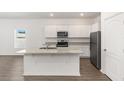 Stylish kitchen boasting white cabinetry, stainless steel appliances, granite countertops, and a convenient center island at 1782 White Elephant Loop, Winter Haven, FL 33884