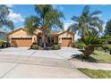 Charming single-story home featuring a three-car garage and mature tropical landscaping at 1892 Sanderling Dr, Clermont, FL 34711