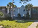Well-kept two-story condo building featuring light blue siding and complemented by vibrant green lawn and mature trees at 3700 Idlebrook Cir # 206, Casselberry, FL 32707