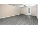 Spacious living room with wood-look floors, neutral walls, and a glass door leading to the outside at 7701 Somersworth Dr, Kissimmee, FL 34747
