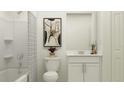 Bright bathroom featuring a shower-tub combo, white cabinets, and modern decor at 2161 Albatross Nest Dr, Bartow, FL 33830