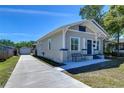 A well-maintained home with a long driveway leading to a detached garage. Bench seating on the front porch at 829 E Lime St, Lakeland, FL 33801