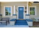 Inviting front porch and blue door featuring updated hardware, seating area, and fresh flowers at 829 E Lime St, Lakeland, FL 33801