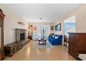 Bright living room with wood floors, a brick fireplace, blue couch and large windows at 642 Lake Dexter Cir, Winter Haven, FL 33884