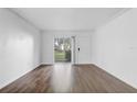 Bright living room boasts wood floors, white walls, and a sliding glass door for natural light at 4215 S Semoran Blvd # 3, Orlando, FL 32822