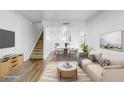 Open-concept living room showcasing the staircase and dining area, enhanced with stylish finishes at 4215 S Semoran Blvd # 3, Orlando, FL 32822