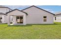 View of the home's rear exterior, showing a sliding glass door and green lawn at 1795 White Elephant Loop, Winter Haven, FL 33884