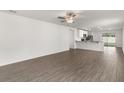Spacious living room features wood-look floors, a ceiling fan, and an open layout to the kitchen at 1795 White Elephant Loop, Winter Haven, FL 33884