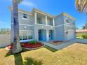 Inviting two-story home with a blue exterior, a covered entrance, and attractive landscaping at 539 Lakeview Dr, Poinciana, FL 34759