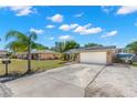 Charming single-story home with a well-manicured lawn, mature landscaping, and an extended driveway leading to a two-car garage at 934 W Heron Cir, Winter Haven, FL 33884