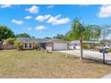 Charming single-story home with a well-manicured lawn, mature landscaping, and an extended driveway leading to a two-car garage at 934 W Heron Cir, Winter Haven, FL 33884