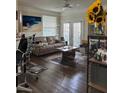 Comfortable living room with wood floors, a beige couch, and natural light from the doors at 3324 Parkchester Square Blvd # 102, Orlando, FL 32835