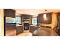 Galley kitchen features stainless steel appliances, stone counter tops, and warm lighting at 472 Blue Heron Cir, River Ranch, FL 33867
