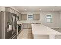 Well-lit kitchen featuring stainless steel appliances, gray cabinets, and a spacious center island at 8249 Sw 52Nd Lane Rd, Ocala, FL 34481
