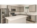 Modern kitchen featuring stainless steel appliances, gray cabinets and a center island at 8249 Sw 52Nd Lane Rd, Ocala, FL 34481