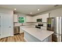 Bright kitchen featuring white cabinets, quartz countertops, stainless steel appliances, and a center island at 5433 Sw 82Nd Ter, Ocala, FL 34481