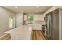 Open kitchen with white cabinets, quartz countertops, stainless steel appliances, and wood-look flooring at 5433 Sw 82Nd Ter, Ocala, FL 34481