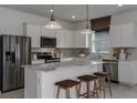 Modern kitchen featuring stainless steel appliances, white cabinetry, marble countertops and eat-in island at 8207 Sw 52Nd Lane Rd, Ocala, FL 34481