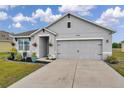 Charming single-Gathering home featuring a well-manicured lawn, flower beds, and a gray two-car garage at 1780 Jackson Oaks Dr, Bartow, FL 33830