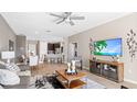 Open-concept living area with a stylish ceiling fan, seamlessly flowing into a modern kitchen and dining space at 5107 Bridgehaven Rd, Davenport, FL 33837