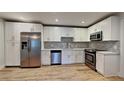 Modern kitchen featuring stainless steel appliances, white cabinets, and a stylish backsplash at 23 Buck Cir, Haines City, FL 33844