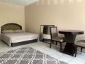 Cozy bedroom featuring a comfortable bed, accent rug, and simple furnishings at 7900 S Orange Blossom Trl # 1099, Orlando, FL 32809