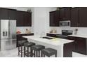 Modern kitchen featuring stainless steel appliances, an island with bar seating and dark wood cabinetry at 1919 Blissful Dr, Kissimmee, FL 34744