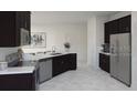 Modern kitchen boasts stainless steel appliances, dark cabinets, and sleek countertops at 2539 Peace Of Mind Dr, Kissimmee, FL 34744
