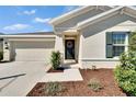 Inviting front entrance with a wreath on the door and manicured landscaping leading to a covered doorway at 272 Pershing St, Bartow, FL 33830
