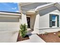 Inviting front entrance with a wreath on the door, complemented by lush landscaping and a covered entryway at 272 Pershing St, Bartow, FL 33830