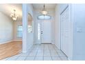Inviting foyer with tile floors, closet, sidelight window, and chandelier lighting fixture at 3518 Remington Oaks Way, Lakeland, FL 33810