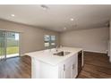 Bright open kitchen with stainless steel appliances, island, and access to a sliding glass door at 1768 Frogmore Ave, Haines City, FL 33844