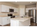 Modern kitchen featuring white cabinetry, stainless steel appliances, an island, and quartz countertops at 1768 Frogmore Ave, Haines City, FL 33844