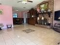 Spacious living room with decorative fireplace, neutral tile floors, and adjoined dining room at 231 Connie Lee Ct, Lakeland, FL 33809