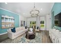 Bright living room with blue accent wall, stylish furniture, and large windows overlooking the yard at 1022 Brimstone Cir, Winter Haven, FL 33884