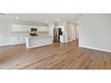 Open kitchen with white cabinets, stainless steel appliances, island and hardwood floors at 1616 Ellesmere Ave, Haines City, FL 33844