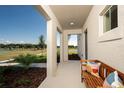Inviting front porch features stylish bench seating, manicured landscaping and open views at 2004 Marigold Aly, Winter Haven, FL 33884