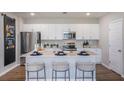 Modern kitchen with stainless steel appliances, white cabinetry, and a large center island at 2004 Marigold Aly, Winter Haven, FL 33884