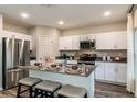 Modern kitchen with stainless steel appliances, white cabinetry, central island, and bar stool seating at 2212 Canyon Oak Dr, Davenport, FL 33837
