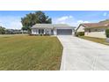 Cozy single-story home with a meticulously maintained lawn and a patterned driveway at 6202 Peacock Run, Lakeland, FL 33809