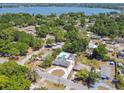 Aerial view of a home featuring a pool and circular driveway near a lake and lush trees at 930 29Th Nw St, Winter Haven, FL 33881