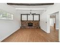 Bright living room featuring wood floors, a brick fireplace, and beamed ceiling at 930 29Th Nw St, Winter Haven, FL 33881