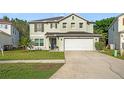 Two story home with a two car garage, neutral colored paint, and well manicured lawn at 16755 Sunrise Vista Dr, Clermont, FL 34714