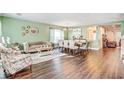 Open living room and dining room with wood floors, light green paint, and large windows at 16755 Sunrise Vista Dr, Clermont, FL 34714