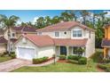 Charming two-story home with a red tile roof, two car garage and well-manicured landscaping at 320 Mockingbird Rd, Davenport, FL 33896