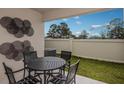 Private patio with a table, four chairs, and decorative metal art at 3856 King Hill Dr, Haines City, FL 33844