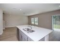 Bright kitchen island, complete with stainless steel sink and faucet, is perfect for meal prep at 4043 Gardenia Ave, Lake Hamilton, FL 33851