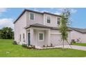 Angled view of a charming two-story home with a well-manicured lawn and a lovely blue front door at 13280 Tula Loop, Astatula, FL 34705