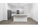 Modern kitchen featuring white cabinets, granite countertops, stainless steel appliances, and wood-style flooring at 13280 Tula Loop, Astatula, FL 34705