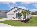 Lovely single-story home with a two-car garage, blue accents, and a well-maintained lawn at 1794 White Elephant Loop, Winter Haven, FL 33884
